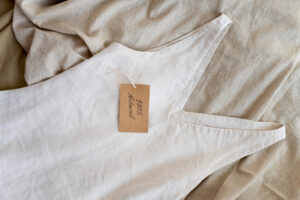 white women dress lying on bed with brown label on it